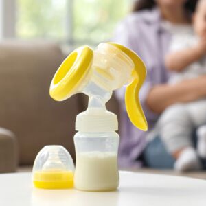 Breast pump on table against mother with baby at home, closeup