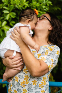 latina mother kissing her daughter. vertical picture