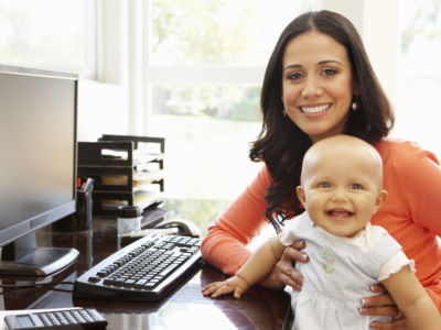 Hispanic mother with baby in working home office